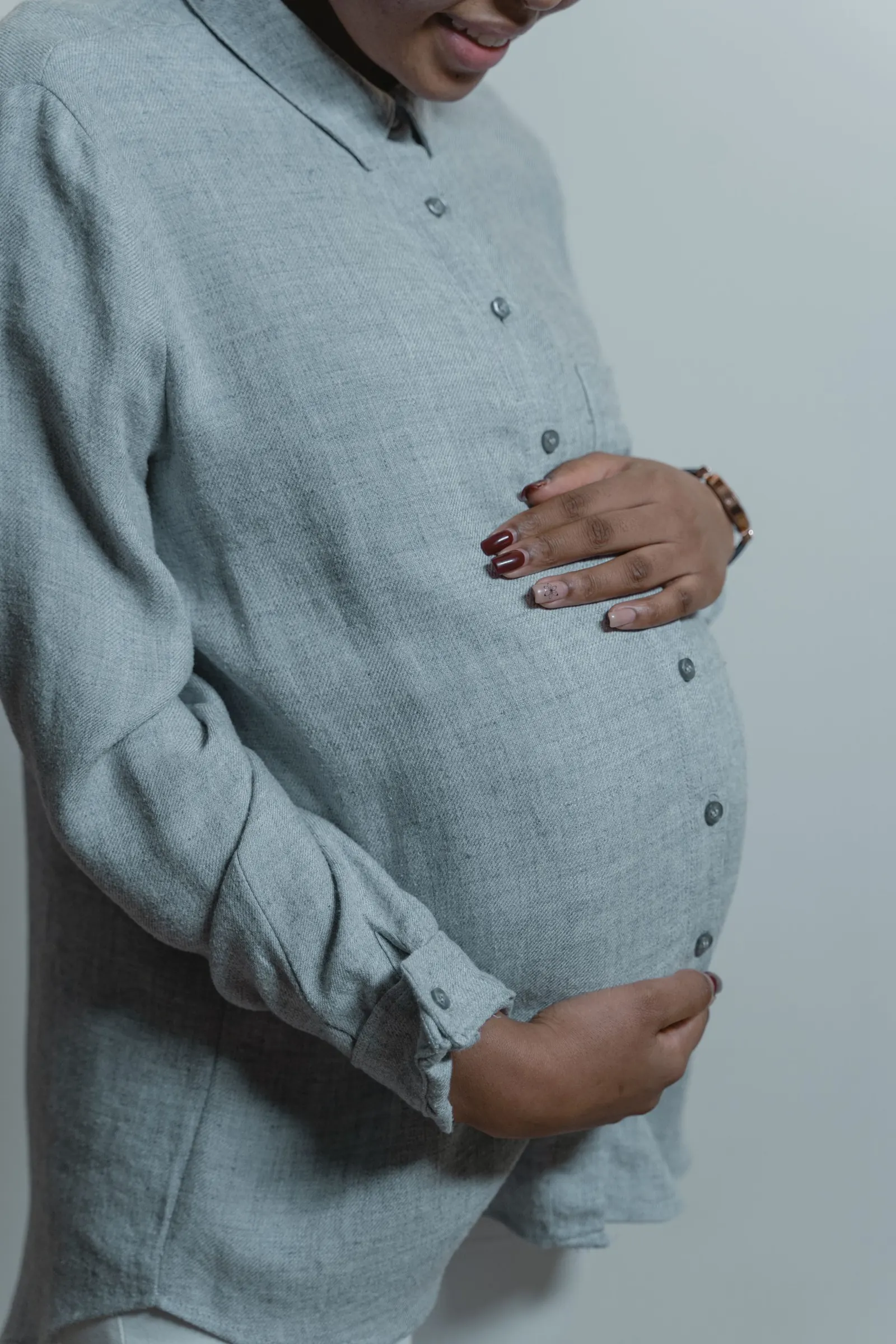 Pregnant woman gently resting her hands on her belly